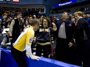Jeff Stoughton of Manitoba leaps into the stands of the John Labatt Centre in London and is congratulated by his wife Hali after winning the 2011 Brier on March 13, 2011. (DEREK RUTTAN/The London Free Press)