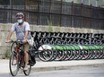 A cyclist rides past a row of Bike Share Toronto rental bikes on Monday July 27, 2020.