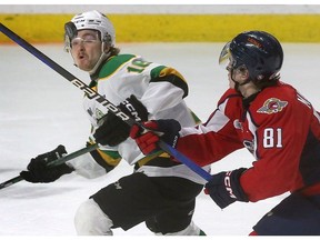 The London Knights' Sean McGurn, left, battles with Windsor Spitfires' captain Matthew Maggio for a high-flying puck during Thursday's game at the WFCU Centre.