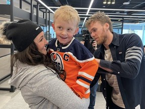 Sarnia's "Zamboni kid," Easton Oetting, 5, beams in the arms of his mother Steph Oetting as Connor McDavid, his hockey hero, signs his sweater in Toronto last week. (Supplied)