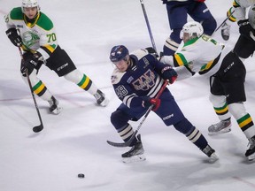 Windsor Spitfires forward Alex Christopoulos fights off London Knights forward Easton Cowen during their game at the WFCU Centre on Saturday March 25, 2023.