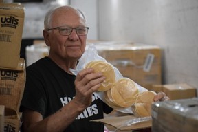 Jim Collins, founder of Harvest Hands food distribution center in St.  Thomas, holds a package of donated pancakes being stored inside a large freezer.  (Calvi Leon/The London Free Press)