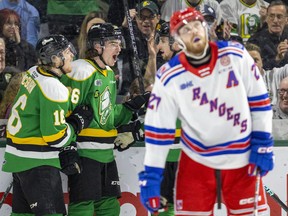 Sean McGurn congratulates London Knights teammate Ryan Winterton after he made the score 3-0 as Logan Mailloux comes in behind a dejected Roman Schmidt of the Kitchener Rangers, who looks up at the score clock in the first period of Game 2 of their OHL second-round series on Friday April 14, 2023. Mike Hensen/The London Free Press