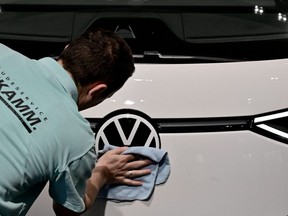 A worker polishes the logo on a Volkswagen ID Buzz electric vehicle during the company's annual press conference on March 14, 2023 in Berlin, Germany. (AFP/Getty Images)