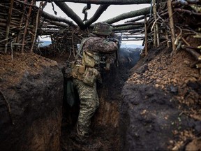 A Ukrainian soldier fires an assault rifle at enemy positions from a trench at an undisclosed location near the town of Bakhmut in the Donetsk region of Ukraine, on April 13, 2023. (ANATOLII STEPANOV/AFP Photo via Getty Images)