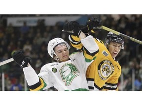 London Knights player Sam Dickinson, left, and Sarnia Sting player Brenden Anderson battle in the first period at Progressive Auto Sales Arena in Sarnia on Saturday, Feb. 18, 2023. (Mark Malone/Sarnia Observer)