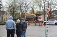 Onlookers watch as demolition crews remove the rubble from the Black Walnut cafe on Wortley Road on Monday, April 17, 2023, following a suspicious fire on Sunday. (Calvi Leon/The London Free Press)