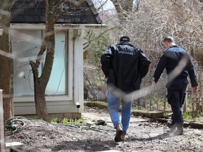 Police officers walk through the backyard at 467 Commissioners Rd. E., where emergency crews were working to dismantle a cannabis extraction laboratory. Photo taken in London on Thursday April 6, 2023. Dale Carruthers / The London Free Press