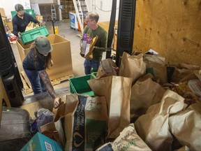 Ken Schmitt, back, Geoff Bergsma, left, and David Little right, are all volunteers at the London Food Bank. They're emptying a van full of donated food Monday April 10, 2023. (Mike Hensen/The London Free Press)