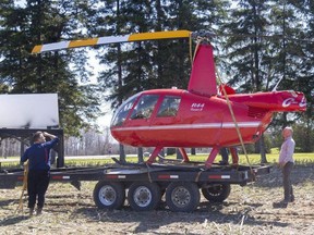 The wreckage of a helicopter that crashed in a field at 8 Mile Road and Wonderland Road north of London is secured on a trailer before being hauled away on Wednesday April 12, 2023. The helicopter, estimated to be worth nearly $500,000, was missing its tail following the crash. Neither occupant was injured, police said. Mike Hensen/The London Free Press