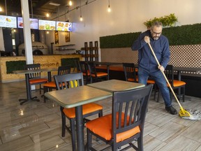 Ashraf Ghareeb is the owner of Barajon, a restaurant in a plaza on Ernest Avenue in London. He is shown mopping up water left on his floor from a $300,000 fire next door at a barbershop.
Photograph taken on Tuesday April 18, 2023.  (Mike Hensen/The London Free Press)