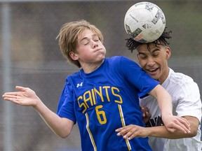 John Paul II player Azariah Hines gets his head on the ball during a battle with Strathroy district collegiate institute opponent Adam Furness during their boys high school soccer game on Monday April 24, 2023 at Western University's Alumni Field. (Mike Hensen/The London Free Press)