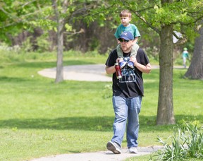 Ed Pinegar walks with his three-year-old son Austin on his shoulders at Greenway Park in London on Sunday.  “We're enjoying May two-four,” Ed said.