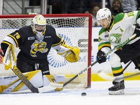 London Knights' Sean McGurn tries to control a puck in front of Sarnia Sting goaltender Ben Gaudreau in Game 3 of the OHL's Western Conference final at Progressive Auto Sales Arena in Sarnia, Ont., on Tuesday, May 2, 2023. (Mike Hensen/Postmedia Network)