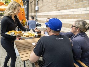 Emma Conley of Jack Astor’s in London serves customers on the patio on Friday, May 5, 2023. Statistics Canada said Friday the London area's unemployment rate of 4.4 per cent in April is the lowest on record. (Mike Hensen/The London Free Press)