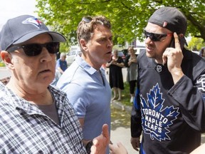 Ward 3 Coun. Peter Cuddy intercedes between a man, right, who identified himself as security for the owner of two apartment buildings at 1270 and 1280 Webster St. in London, and an elderly man at a rally at the buildings organized by a tenants' advocacy group on Friday, May 12, 2023. (Mike Hensen/The London Free Press)