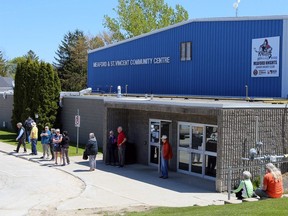 Meaford residents line up outside the Meaford and St. Vincent Community Centre waiting for a shipment of bottled water to arrive on Friday. (Greg Cowan/Postmedia Network)