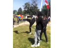 A person kicks a Pride flag as others cheer after he pulled it down at London's Sir Frederick Banting secondary school on Tuesday June 6, 2023. (Screen grab)
