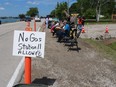 A group of neighbours and community residents gathered along River Road at Aamjiwnaang First Nation on June 3, 2021, to stop construction of a gas station.