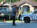 A member of the Special Investigations Unit collects evidence on July 21, 2023, outside of 66 Glenroy Rd. in London after London police fatally shot a 35-year-old man, who was a suspect in an attempted vehicle theft and shooting. (Dale Carruthers/The London Free Press)