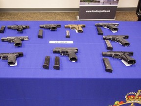 London police display some of the 26 guns seized during a raid