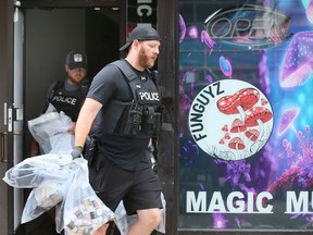 Windsor police officers carry bags of seized materials from the FunGuyz location at 359 Ouellette Ave. in downtown Windsor on July 6, 2023.