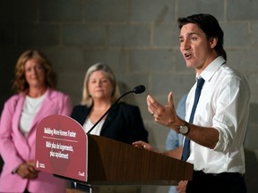 Prime Minister Justin Trudeau speaks during a visit to an apartment complex under construction in Hamilton, Ont., July 31, 2023. The sign on the lectern reads “building more homes faster.”