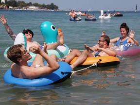 Sven Ole Mahlow, front left, Colton McGugan, back left, Jan-Nicklas Mahlow and Jacqueline Vercouteren set off from north of the Blue Water Bridge in the annual Port Huron Float Down Sunday. A Canadian Coast Guard official estimated 4,000 people took part in the unsanctioned event. (Tyler Kula/ The Observer)