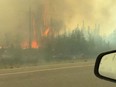 A vehicle travels on the freeway as people evacuate from Yellowknife, Northwest Territories, due to an approaching wildfire, on August 16, 2023.