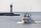 An OPP boat returns to shore past the light of Port Stanley harbor on Friday, Sept. 1, 2023, during a search for a 64-year-old from London who went missing in Lake Erie while swimming from a boat Thursday afternoon.  (Mike Hensen/The London Free Press)