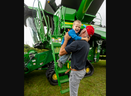 Steve Klijn of Bothwell catches his son Hendrick, 4, as he jumps down from the steps of a huge John Deere combine at Canada's Outdoor Farm show, which began its three-day run in Woodstock on Tuesday Sept. 12, 2023. (Mike Hensen/ The London Free Press)