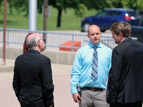 Andrew Fickling stands outside the Sarnia courthouse alongside his family and lawyer during one of his sentencing hearings for arson linked to a fire in January 2022. Terry Bridge/Sarnia Observer/Postmedia Network
