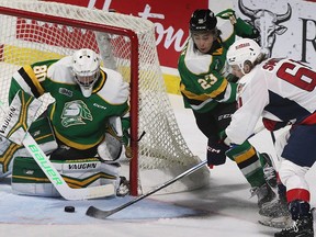 London Knights' backup goalie Owen Willmore makes save on the Windsor Spitfires' Colton Smith while teammate Sam O'Reilly moves in to help on Thursday.
