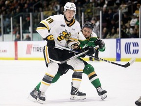 Sarnia Sting's Kai Schwindt (20) is checked by London Knights' Alec Leonard (27) in the first period at Progressive Auto Sales Arena in Sarnia, Ont., on Thursday, Dec. 28, 2023. (Mark Malone/Postmedia Network)