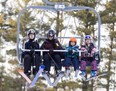 Skiers take the chair lift