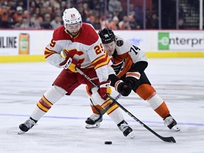 Lawyers for Dillon Dube say the Calgary Flames forward has been charged with sexual assault by police in London in connection to allegations involving Canada's 2018 world junior hockey team. Dube, left, skates the puck past Philadelphia Flyers' Owen Tippett in Philadelphia on Saturday, Jan. 6, 2024.