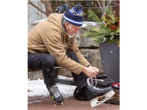 John Lamont from Tillsonburg laces up his skates before taking his granddaughter Leigha Kay, 6, of London for a skate in Storybook Gardens on Saturday Jan. 6, 2023. (Mike Hensen/Postmedia Network)
