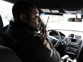 Corporate Protection and Investigative Services Regional Staff Supervisor Shawn Jones in a mobile patrol vehicle taking a call on the radio.