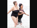 Julie Boyse of Woodstock (left) and Sue Wilson of Port Burwell react to the frigid water of Lake Erie as they partake in the Port Burwell Polar Bear Swim on Monday Jan. 1, 2024. Asked why she did it, Boyse said: “I want to be more spontaneous this year and get out of my comfort zone.” (Derek Ruttan/The London Free Press)