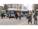 Riders get off London Transit buses at Fanshawe College in London, Ont. on Monday, Feb. 12, 2024. One observer sees London council's refusal to fund additional service hours is a