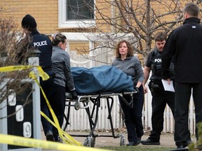 Staff from Smith Funeral Home in Sarnia take a body out of unit four at 219 Queen St. in Sarnia on Wednesday, Feb. 21, 2024, with the help of Sarnia police and firefighters. Police are investigating the death as a homicide. (Terry Bridge/Sarnia Observer)