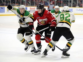 Owen Sound Attack player Sam McCue tries to split the defence of Landon Sim (90) and Jackson Edward of the London Knights in the first period at the Harry Lumley Bayshore Community Centre on Saturday, Feb. 17, 2024. Greg Cowan/The Owen Sound Sun Times