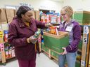 Volunteers Norma Nevison, left, and Cindy Thomas load boxes at the London Food Bank on Wednesday, March 20, 2024. (Derek Ruttan/The London Free Press)