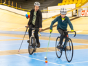 Jordan Bowden of the Forest City Bike Polo club helps Kellen Burton, 11, with a few pointers at the London Bike Show at the Forest City Velodrome on Sunday April 7, 2024. Mike Hensen/The London Free Press