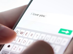 Sending I love you text message with mobile phone.