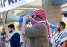 Men with megaphones lead pro-Palestinian protesters in chants as they occupy the lawn outside the University Community Centre at Western University in London on Wednesday, May 1, 2024. (Derek Ruttan/The London Free Press)