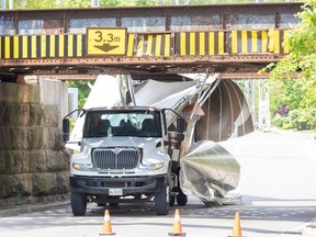 A truck hauling kegs of beer is wedged under the Talbot Street rail bridge in London after its driver struck a steel beam in front of the bridge while trying to drive under it on Tuesday, May 14, 2024. (Derek Ruttan/The London Free Press)