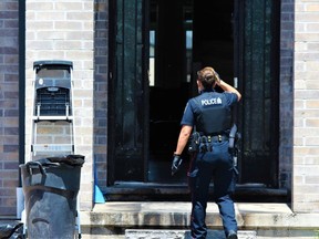 A London police officer enters a home on Wateroak Drive