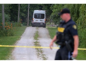 An Ontario Provincial Police officer is shown at a home in the 1200 block of County Road 13 in Harrow on Thursday, June 20, 2024.