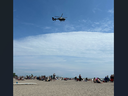 A police helicopter flies above Port Stanley as emergency crews search for a swimmer who did not resurface after entering the water on July 14, 2024.
